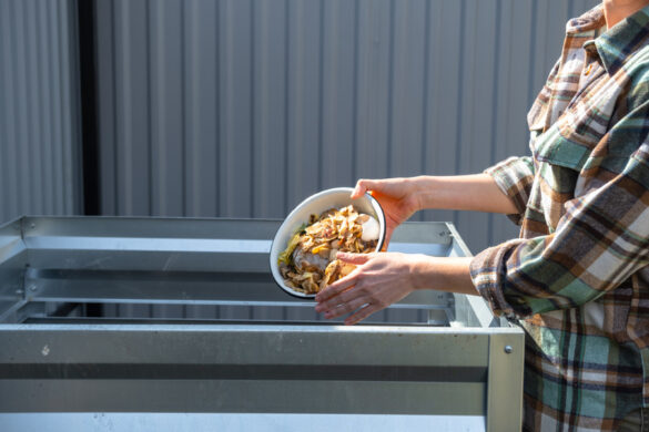 Une personne versant un bol contenant de frites dans un bac à compost.