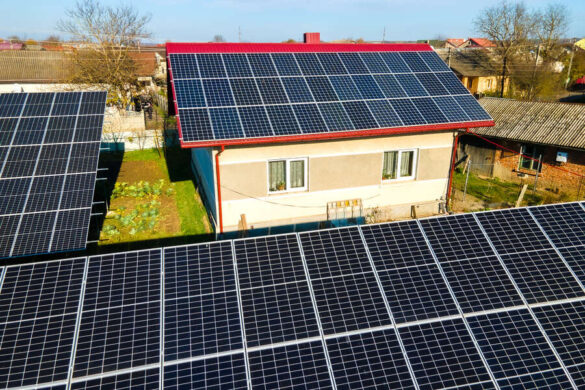 Plusieurs panneaux solaires installés sur des grandes maisons se trouvant à la campagne.