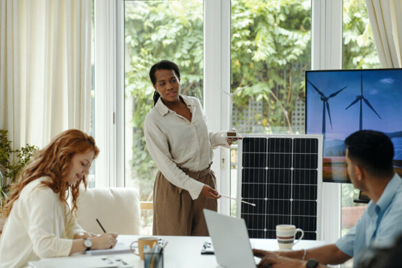 Une femme d'affaire et deux autres personnes étudiant l'énergie apporté par un panneau solaire de 4000w.