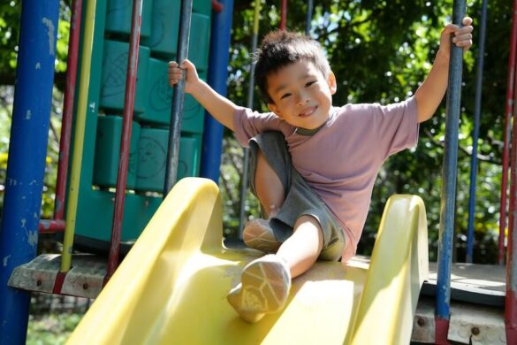Un enfant joue dans son jardin prés du poulailler