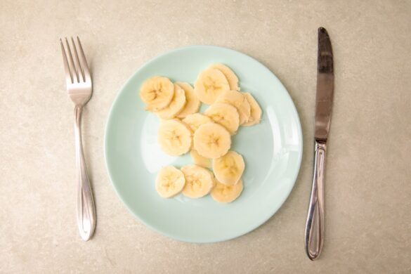 Une assiette de banane tranchée avec un couteau et une fourchette sur la table
