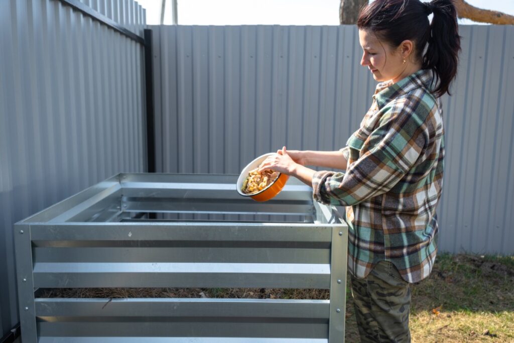 Une femme mettant des déchets alimentaires dans un bac à compost