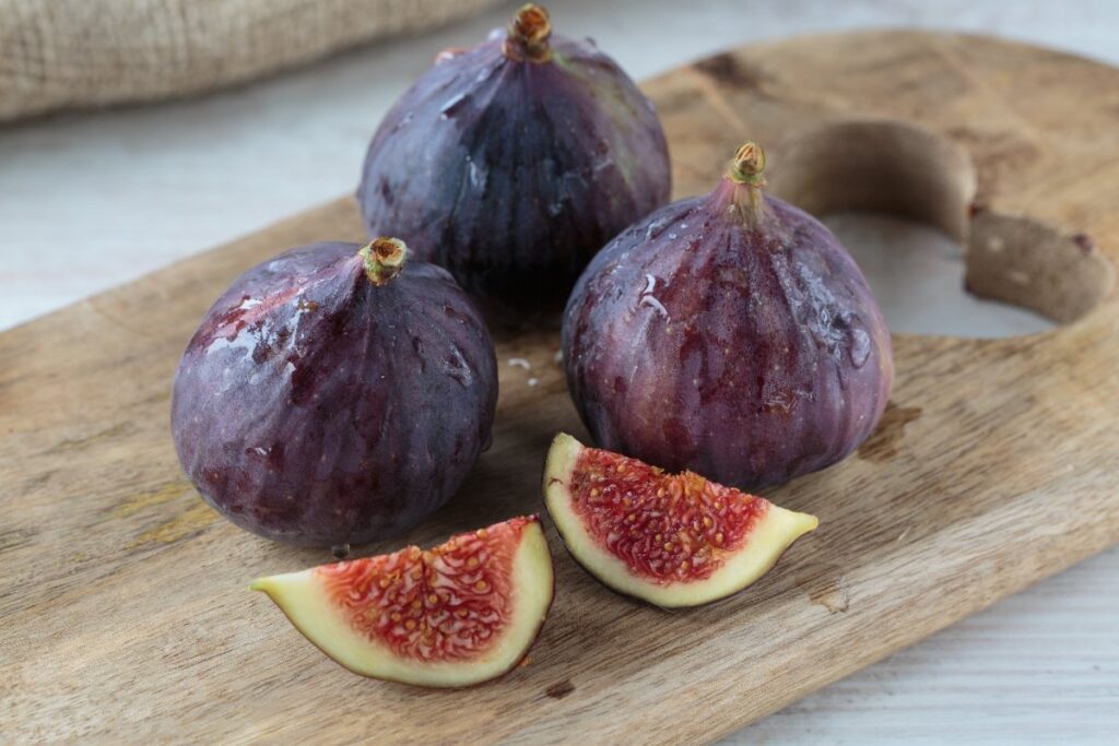 Des figues fraîches sur une planchette en bois