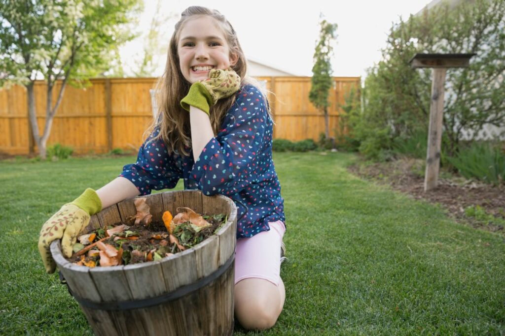 Une jeune fille souriante tenant un pot rempli de compost